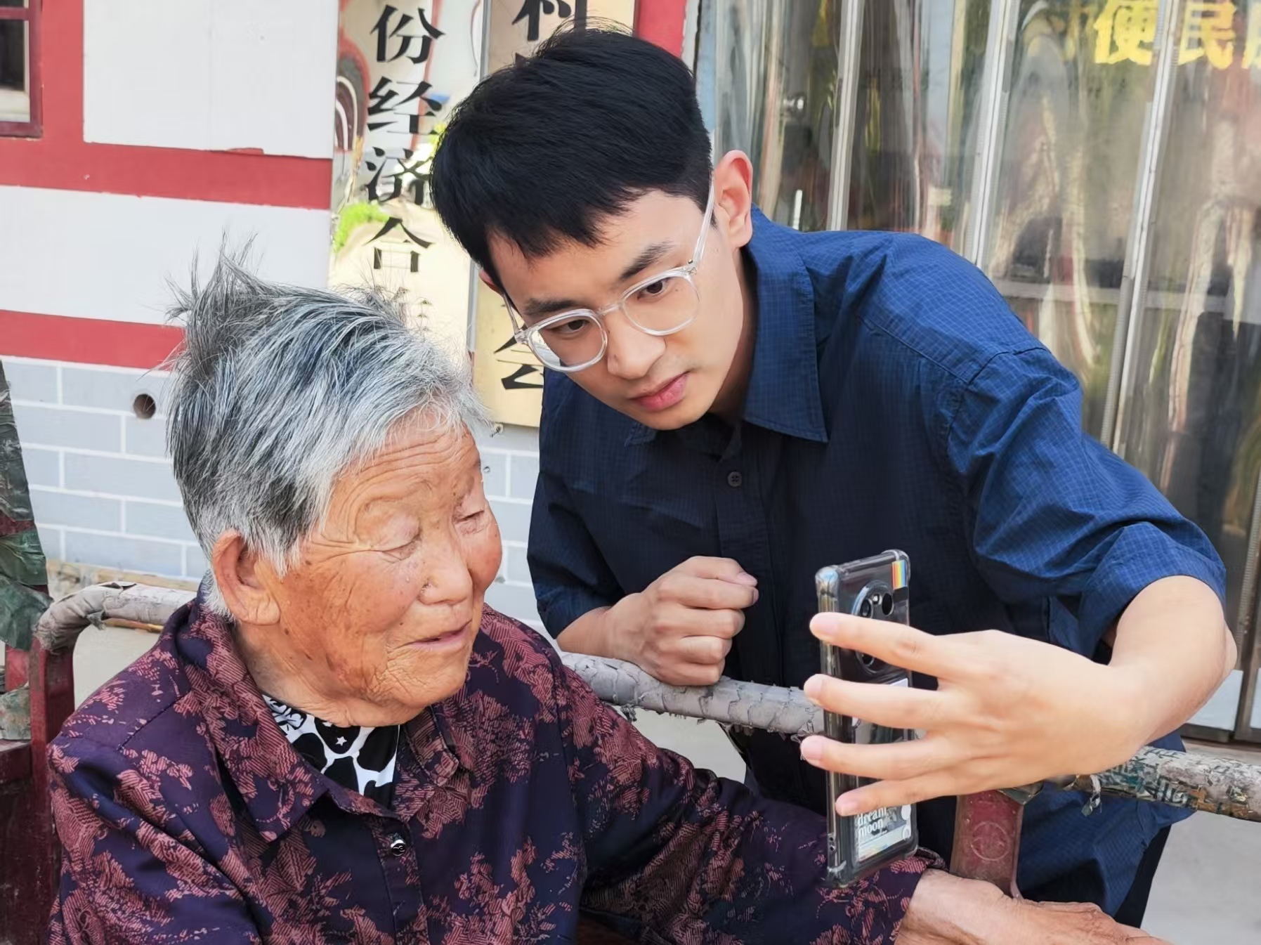 石文喆（右）幫助老人進行養老保險認證。（瓦崗寨村村委會 供圖）.jpg